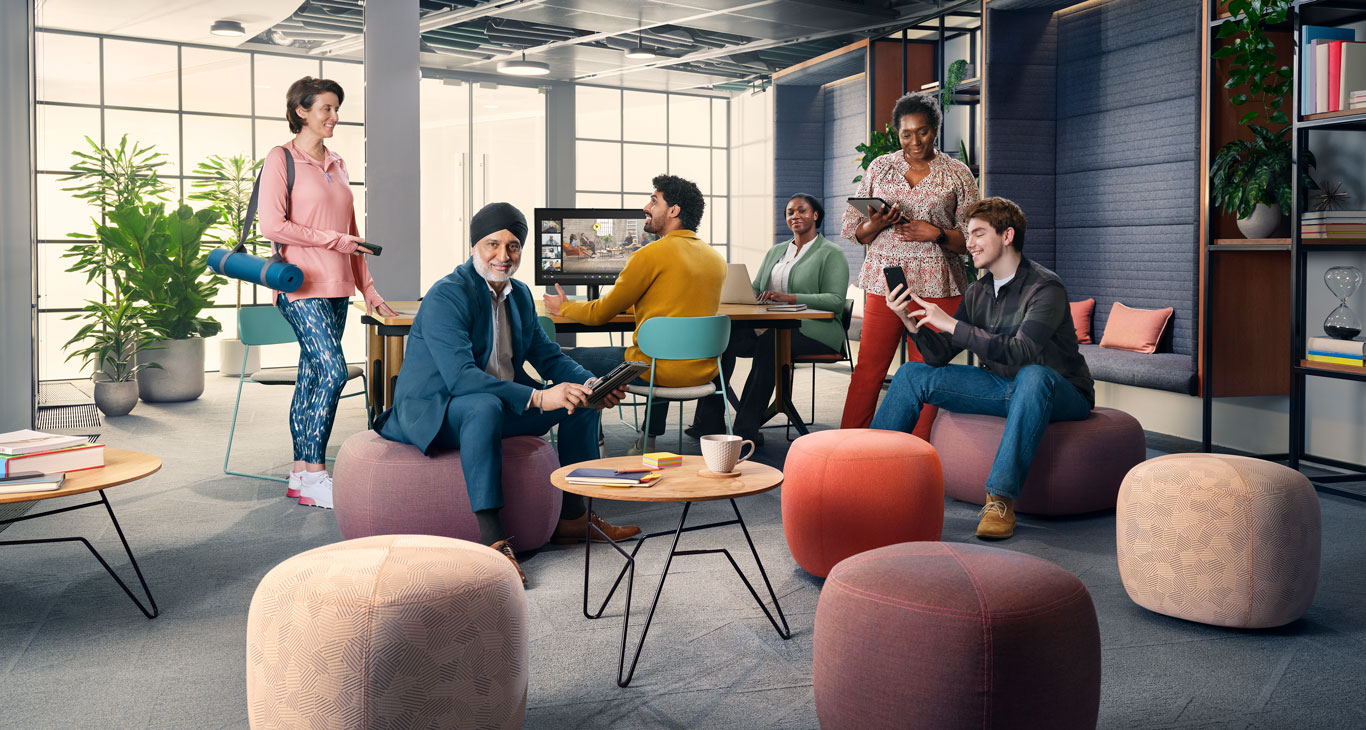 Six people posing in an informal office space